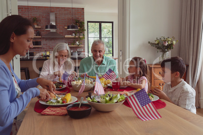 Multi-generation family having food on dining table at home