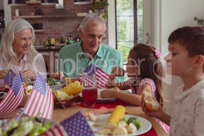 Multi-generation family having food on dining table at home
