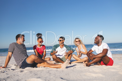 Group of friends interacting with each other on the beach