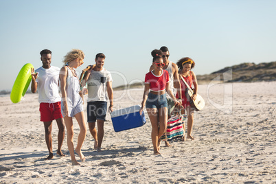 Group of friends walking together on the beach
