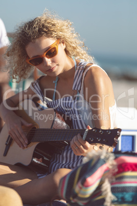 Woman playing guitar on the beach Woman playing guitar on the beach