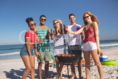 Group of friends toasting beer bottles on the beach