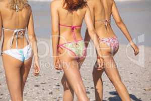 Group of female friends walking together on the beach