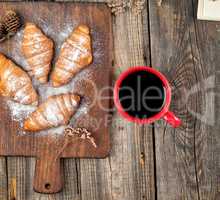 ceramic red cup with black coffee and wooden cutting board with