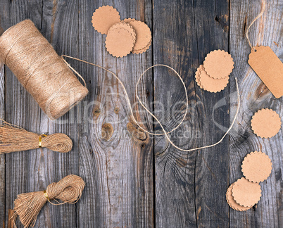 coil of brown rope, paper tags on a gray wooden background