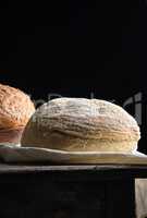 baked round white wheat bread on a textile towel, wooden old tab