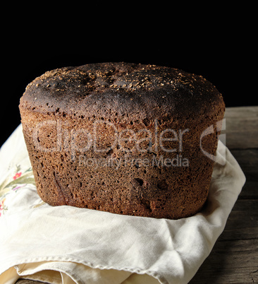 baked rye bread lies flour on a textile towel
