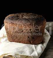 baked rye bread lies flour on a textile towel