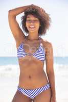Happy woman in bikini looking at camera on the beach