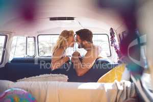 Romantic couple sitting in a camper van at beach
