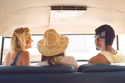 Group of friends interacting with each other in a camper van at beach