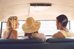 Group of friends interacting with each other in a camper van at beach
