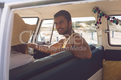 Couple interacting with each other in a camper van at beach
