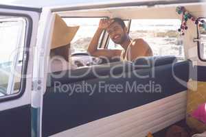 Couple interacting with each other in a camper van at beach