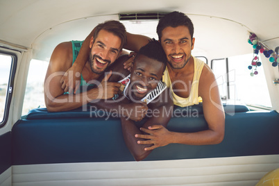 Male friends having fun in a camper van at beach