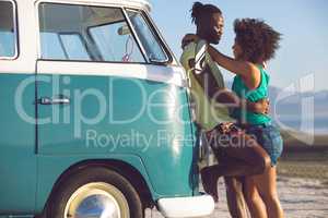 Couple embracing each other near camper van at beach