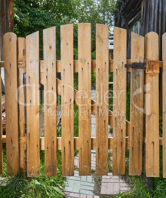 wooden gate closed on a bolt from a natural tree