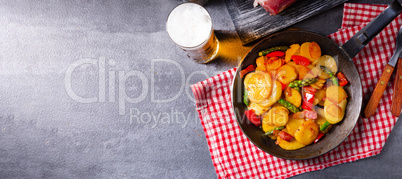 Fried potatoes with smoked bacon, green asparagus and paprika.