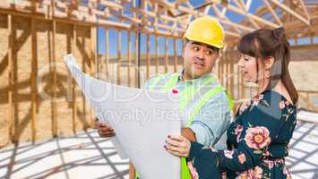 Hispanic Male Contractor Talking with Female Client Over Blueprint