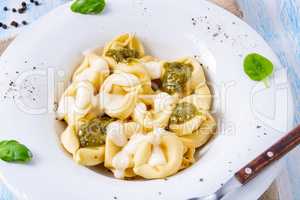 Tortellini di formaggio with basil pesto and cheese sauce