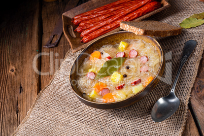 rustic sauerkraut soup with bacon and sausage