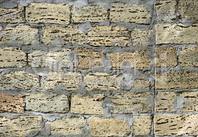 brick wall of large stone blocks fastened with gray cement