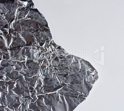 ragged edge of silver foil on a white background