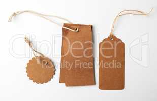 various brown paper tags with ropes on white background