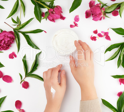 two female hands and a jar with thick cream
