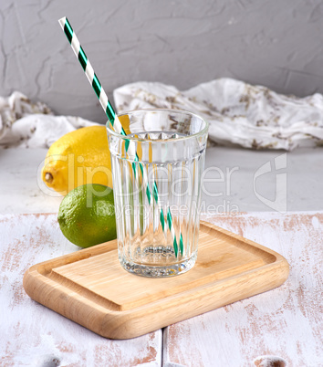 empty glass with facets and green cocktail tube