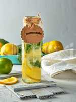 lemonade with lemons, mint leaves, lime in a glass bottle