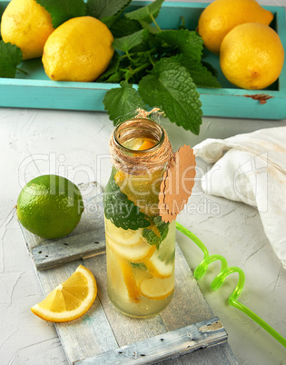 drink lemonade in a glass bottle and ripe fresh lemons