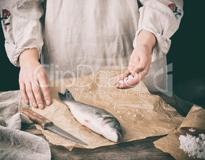 fresh whole sea bass fish lying on brown paper