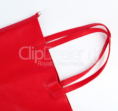 fragment of a red leather bag with handles on a white background