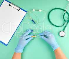 two doctor's hands in sterile blue gloves holding a drip for