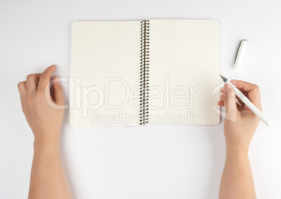 two female hands holding open notepad with clean sheets
