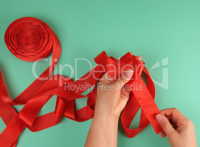 two female hands and red silk ribbon