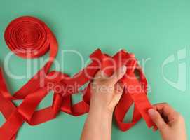 two female hands and red silk ribbon