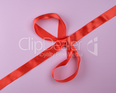 red silk ribbon tied in a big bow, festive background