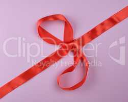 red silk ribbon tied in a big bow, festive background