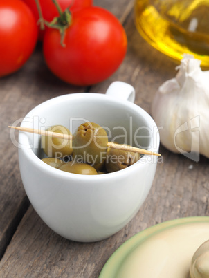 Tasty green olives on a wooden table