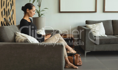 Woman using mobile phone in lobby at hospital