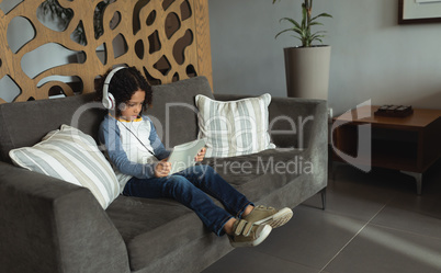 Boy listening music on digital tablet in the lobby at hospital