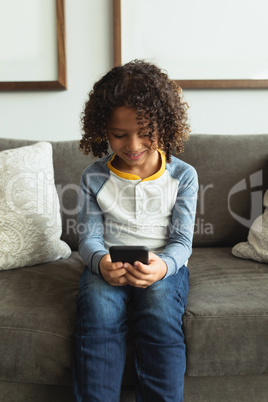 Boy using mobile phone in the lobby at hospital