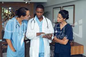Doctors discussing over digital tablet in the hospital