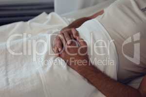 Male patient lying on bed in the ward at hospital