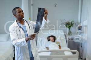 Male doctor examining x-ray report in the ward