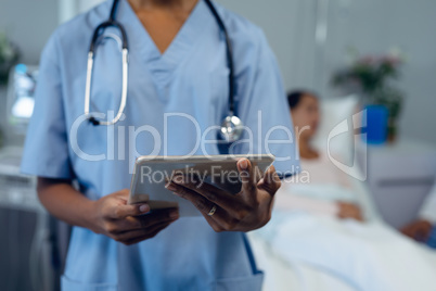 Female doctor using digital tablet in the ward at hospital