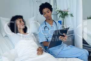 Female doctor interacting with female patient in the ward