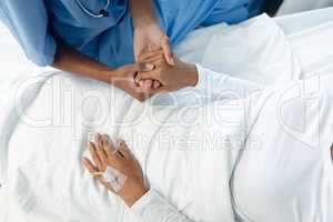 Female doctor consoling female patient in the ward at hsopital